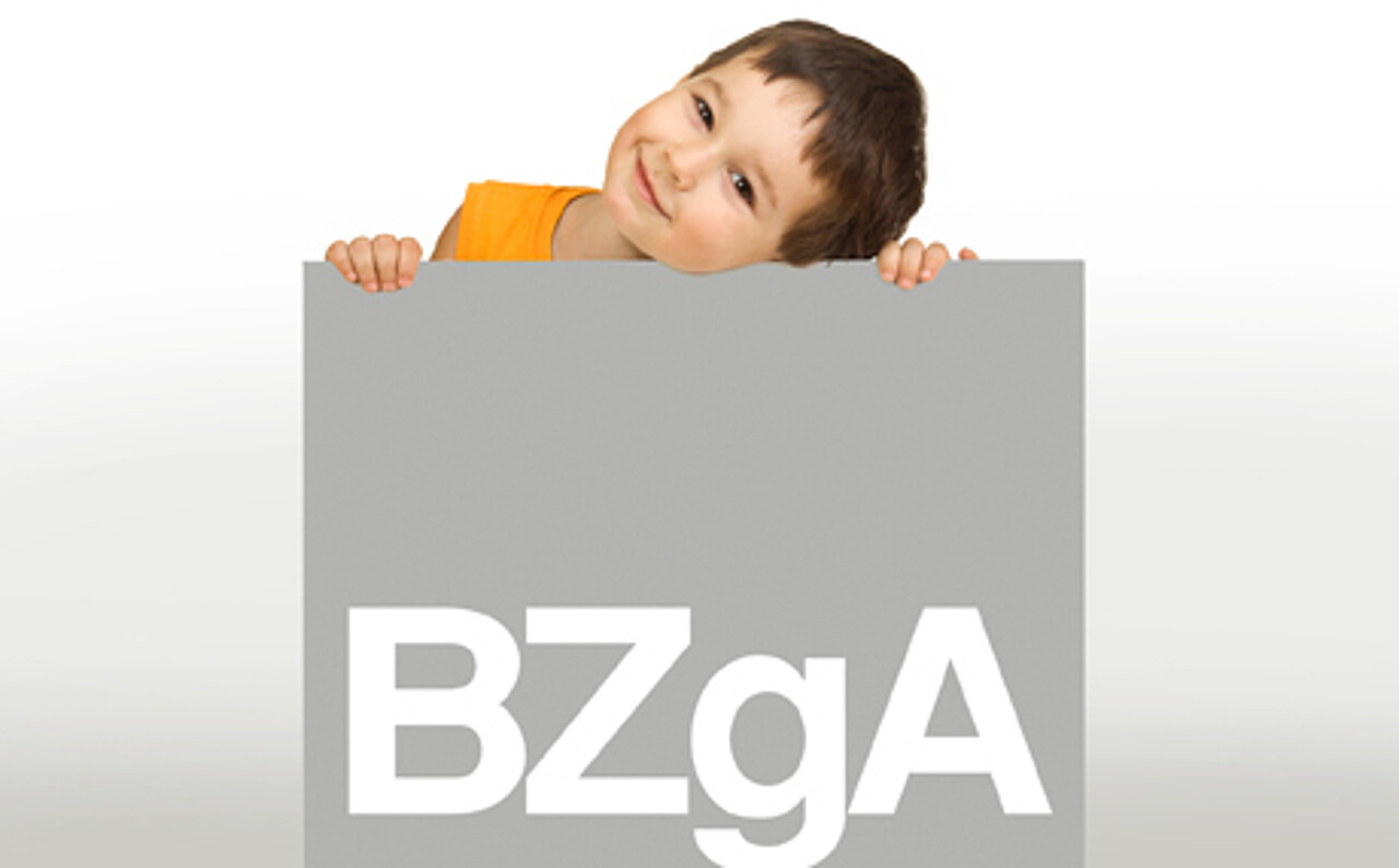 kleiner Junge hält ein Schild mit dem Logo der BZgA in den Händen