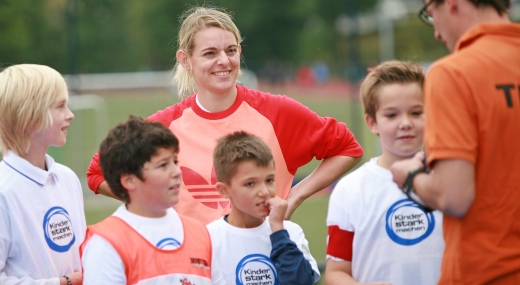 Nia Künzer Nia Künzer mit Kindern auf dem Sportplatz