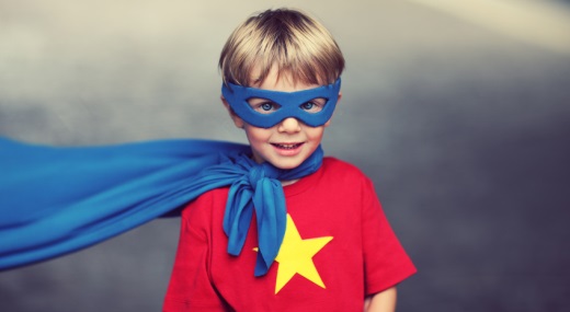 Supermann Junge mit einem roten T-Shirt mit gelbem Stern trägt eine blaue Maske und einen blauen Umhang