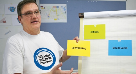 Kursleiter einer „Kinder stark machen“-Schulung spricht vor einer Flipchart
