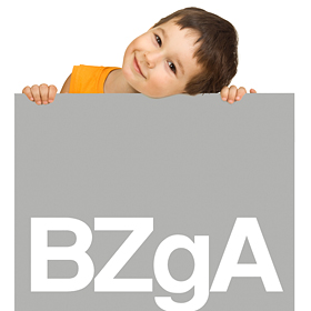 Junge lächelt und hält ein Schild mit BZgA Logo