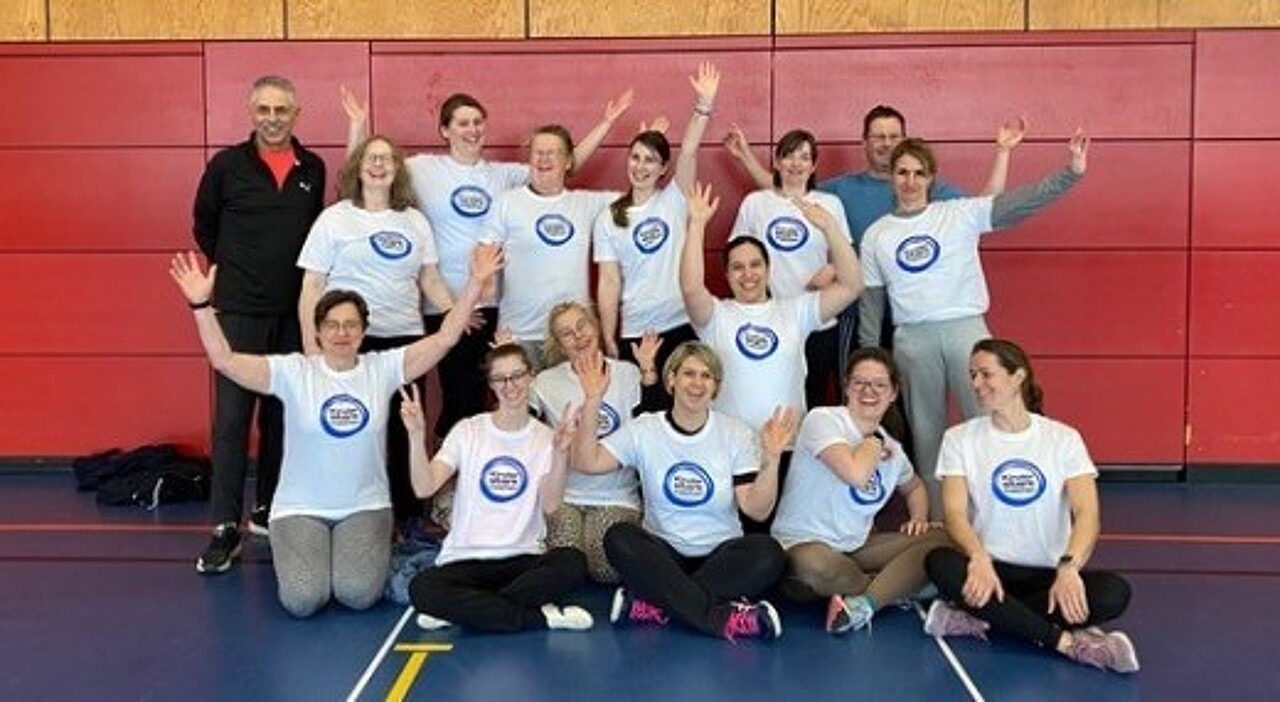 Die Schulungs-Teilnehmerinnen und Teilnehmer posieren im „Kinder stark machen"-T-Shirt mit Dr. Harald Schmid.