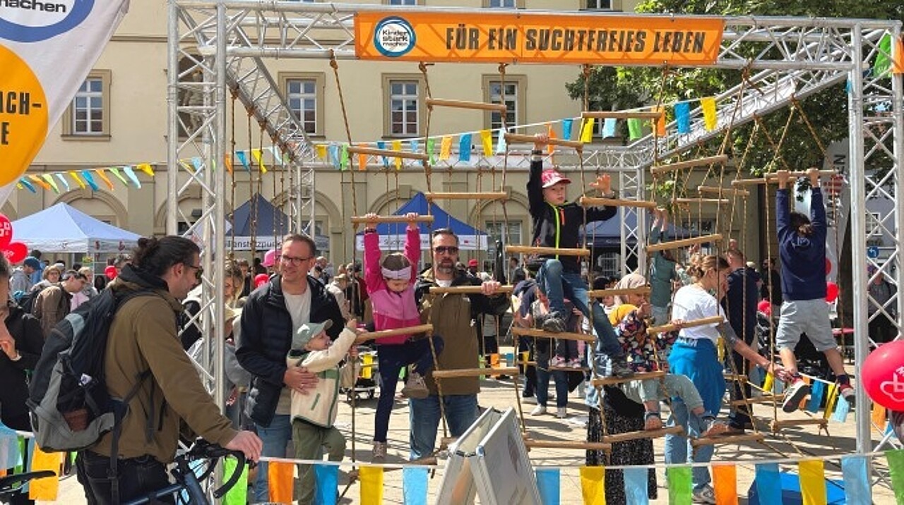 Kinder im Klettergarten. Eltern geben Hilfestellung.