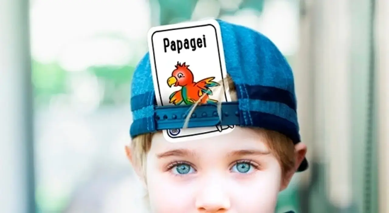 Junge mit Tier-Spielkarte in Kappe