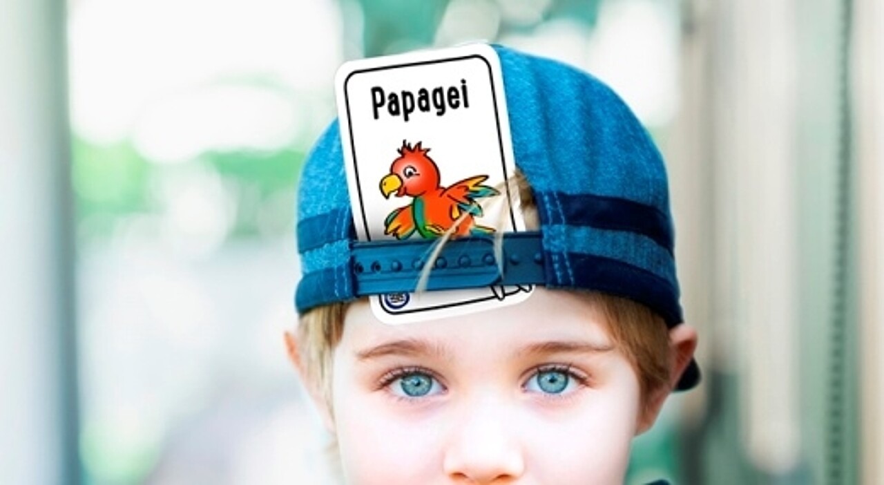 Junge mit Tier-Spielkarte in Kappe