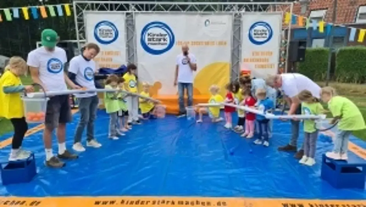 Kinder auf der „Kinder stark machen“-Spielbühne lassen Bälle durch Röhren rollen.