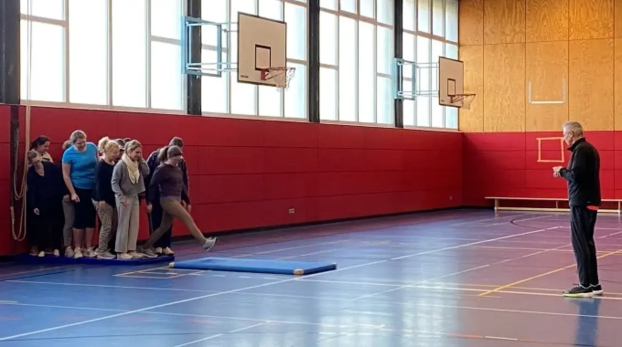 Und los gehts: Die Teilnehmerinnen und Teilnehmer stehen Schlange, um eine Übung auf einer Matte zu absolvieren.