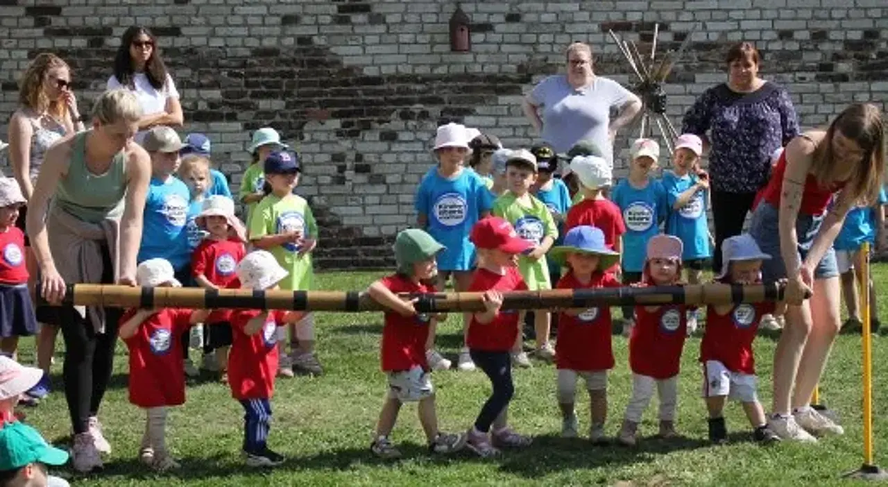 Kita-Kinder und Erzieher beim Baumholzziehen