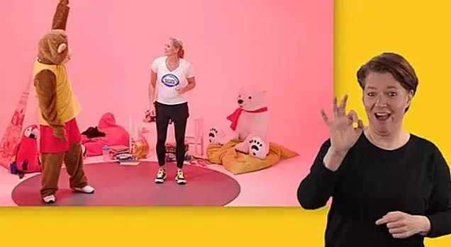 Singa mit dem DTB-Maskottchen beim Turnen: In Vordergrund die Gebärdensprachdolmetschern