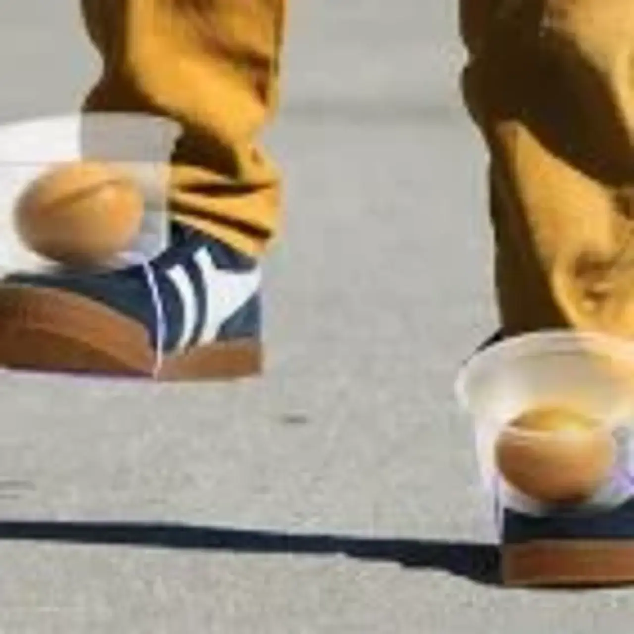 Zwei Kinderbeine mit Plastikbechern an den Schuhen