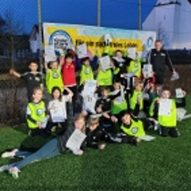 Die Kinder mit ihren Urkunden vor dem  „Kinder stark machen“-Banner