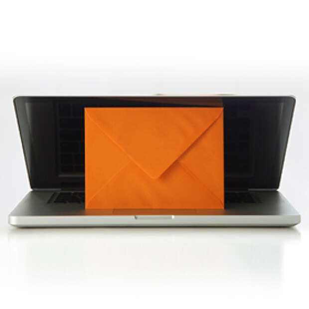 orangefarbener Briefumschlag in aufgeklapptem Laptop