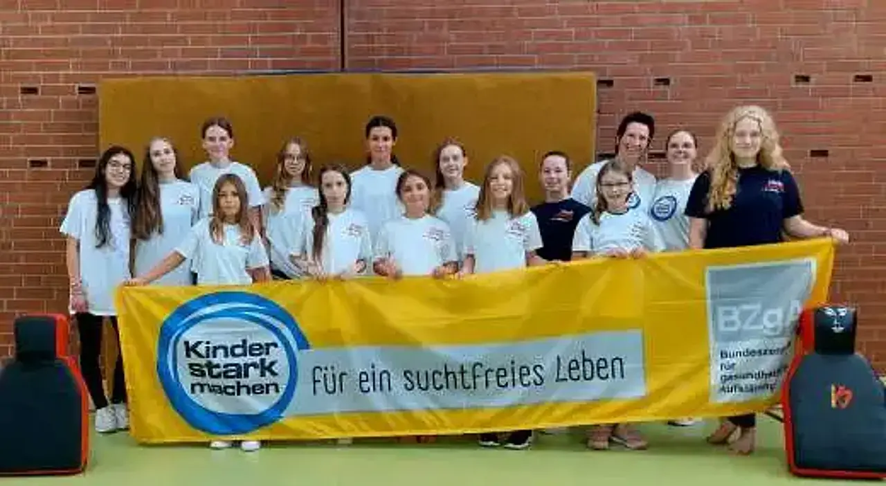 Gruppenabild der Teilnehmerinnen des Selbstvertrauens- und Selbstverteidigungswochenendes mit dem Kinder stark machen-Banner.