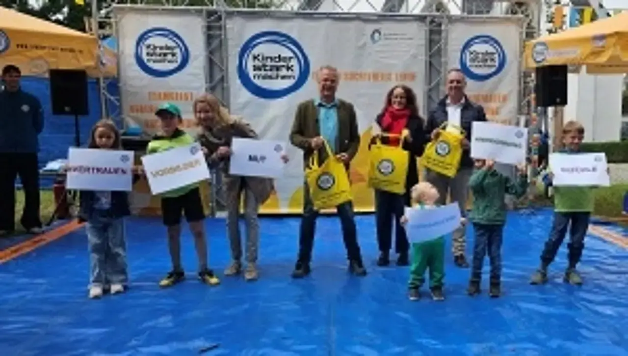 Gemeinsam mit der Botschafterin des Familientages Theresa Weißbach und weiteren offiziellen Gästen halten die Kinder Wortkarten mit den wichtigen Kernbotschaften von Kinder „Kinder stark machen“ wie Vertrauen, Mut etc. hoch.