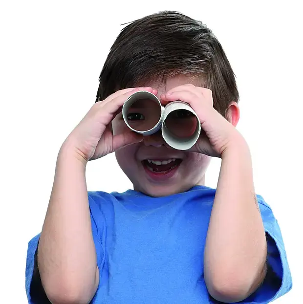 kleiner Junge guckt durch ein Fernglas aus leeren Toilettenpapierrollen