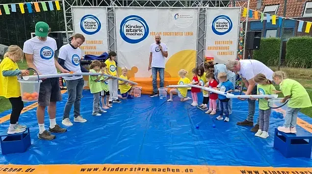 Kinder auf der „Kinder stark machen“-Spielbühne lassen Bälle durch Röhren rollen.