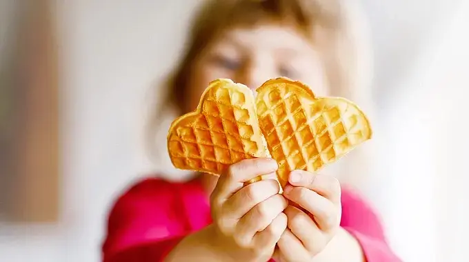 © Romrodinka - bigstockphoto Ein Kind hält eine Waffel in die Kamera