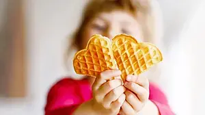 © Romrodinka - bigstockphoto Ein Kind hält eine Waffel in die Kamera
