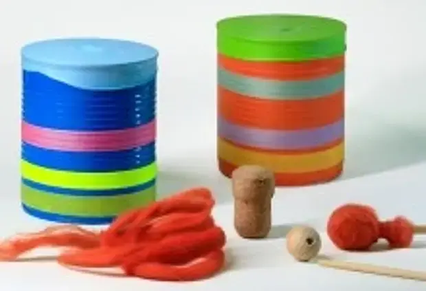 Die Dosentrommel, daneben Stäbchen, Holzperle, Korken und rote Wolle für den Bau der beiden Schlägel-Varianten..