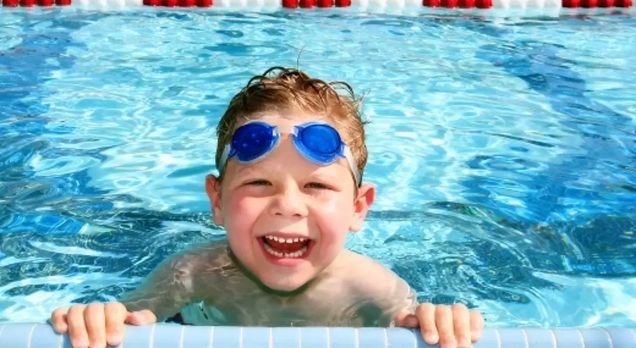 © Acik/bigstockphoto Vor Freude grinsender Junge im Freibad