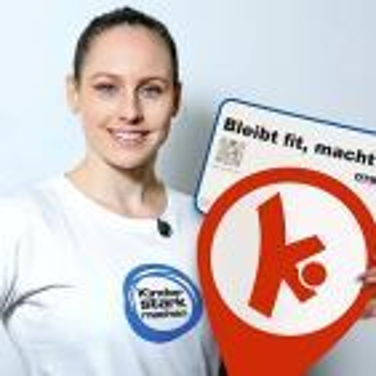 Sarah Voss hält ein Schild der Bewegungshaltestellen in der Hand