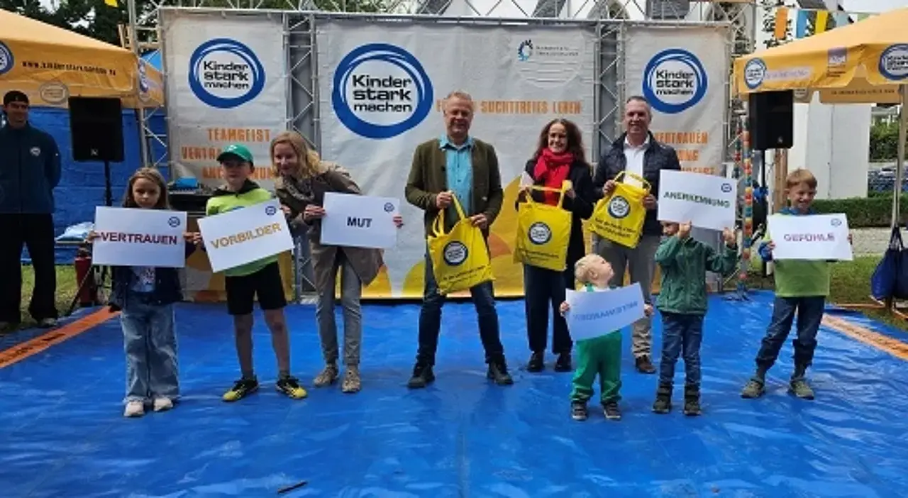 Gemeinsam mit der Botschafterin des Familientages Theresa Weißbach und weiteren offiziellen Gästen halten die Kinder Wortkarten mit den wichtigen Kernbotschaften von Kinder „Kinder stark machen“ wie Anerkennung, Vertrauen, Mut etc. hoch.