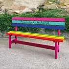 Bunt angemalte Holzbank, die in Schreibschrift den Schriftzug Freundschaftsbank trägt.