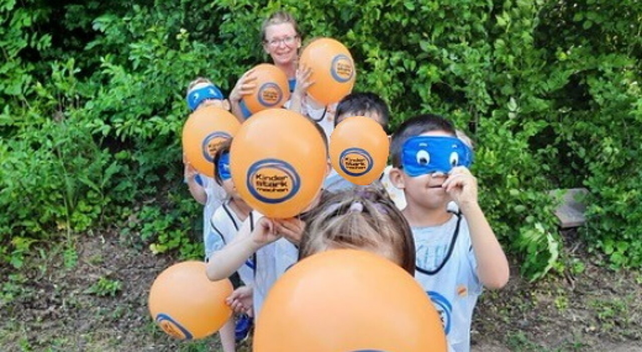 Kinder mit Luftballons und Schlafmasken