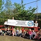 Einige Kinder und Lehrkräfte halten das personalisierte Banner der Sport-Grundschule Passau-Grubweg hoch