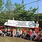 Einige Kinder und Lehrkräfte halten das personalisierte Banner der Sport-Grundschule Passau-Grubweg hoch