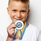 Junge zeigt seine gebastelte Medaille