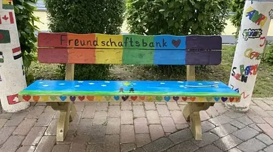 Die in Regenbogenfarben angemalte Freundschaftsbank auf dem Schulhof.
