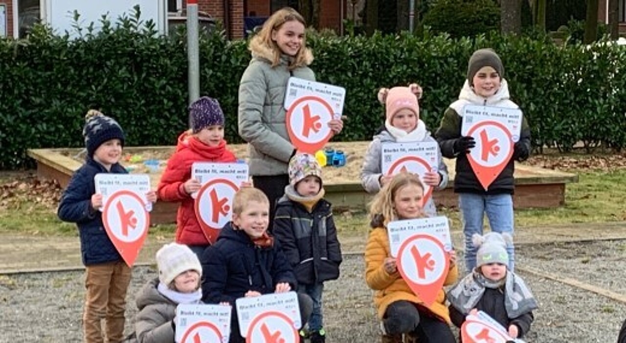 Kinder aus Petersdorf zeigen die Bewegungshaltestellen Schilder