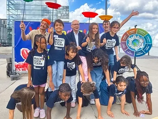 Dr. Johannes Nießen mit Kindern bei der Teller-Jonglage