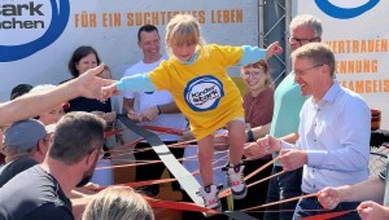 Dominik Klein mit hohem Besuch auf der Aktionsbühne - Gemeinsam spannen sie das Teambalancierband, über das es Mädchen balanciert.