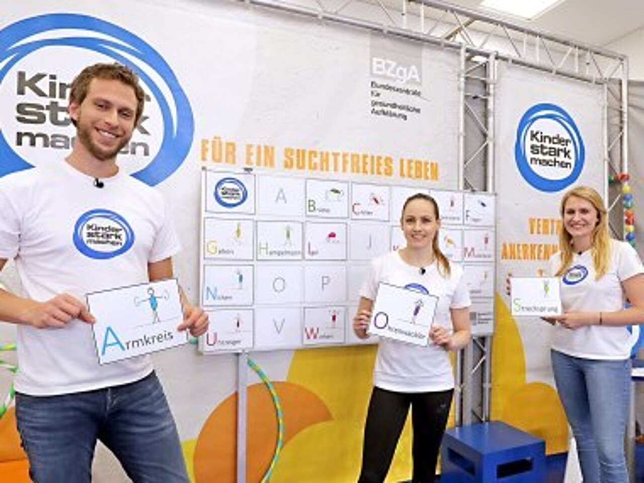 Philipp, Sarah und Lisa zeigen die Buchstaben für das Bewegungs-ABC