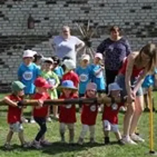 Kita-Kinder und Erzieher beim Baumholzziehen