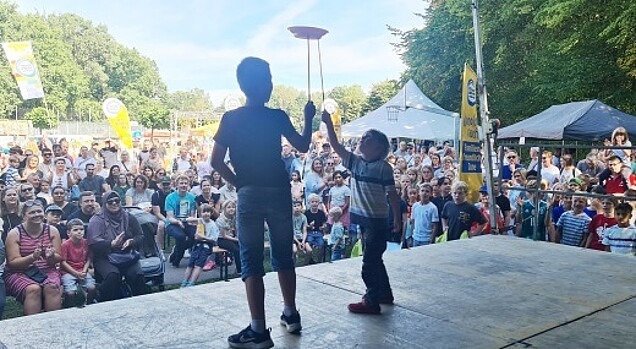 Zwei Kinder auf der Bühne bei der Tellerjonglage vor großem Publikum