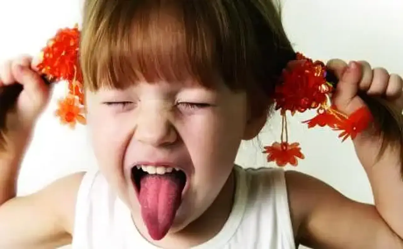 Konflikte Kleines, rothaariges Mädchen schreit und zieht sich dabei an den Zöpfen