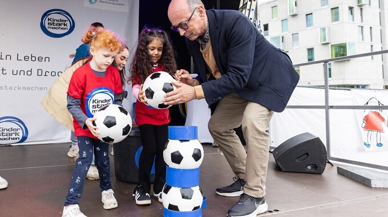 Der Kommissarische Leiter des Bundesinstituts, Dr. Johannes Nießen, beim Ballturmwettbewerb mit Kindern auf der BIÖG-Bühne