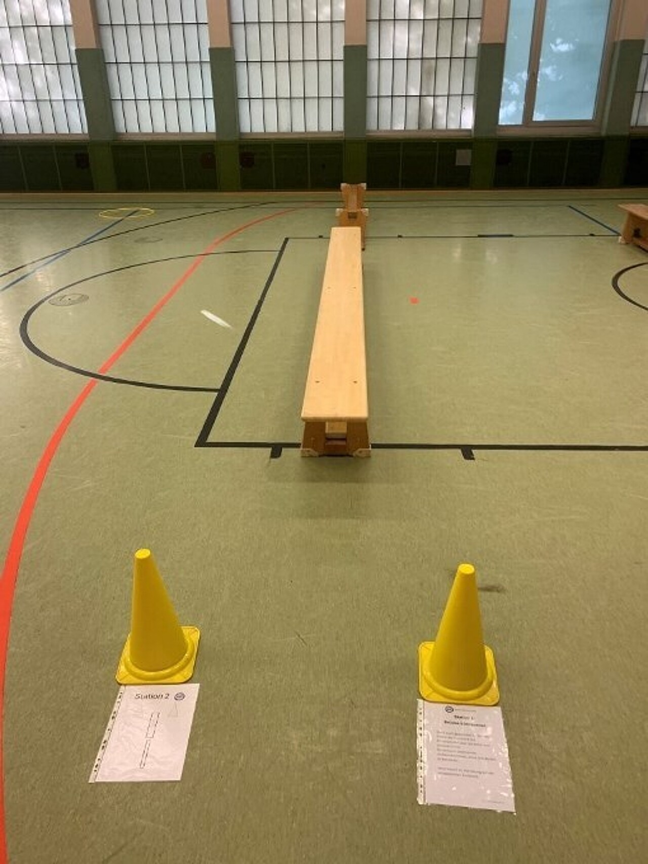 Zwei längs hintereinandergestellte Turnbänke, eine davon ist auf die Sitzfläche gedreht