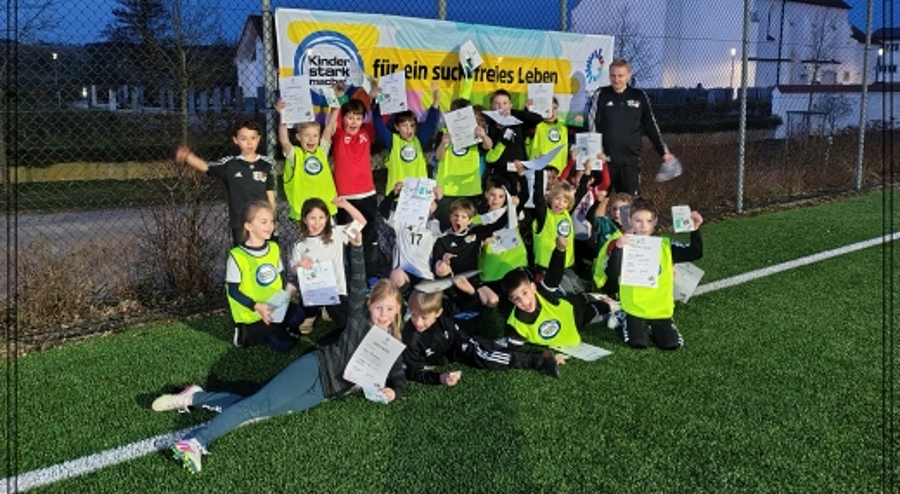 Die Kinder mit ihren Urkunden vor dem  „Kinder stark machen“-Banner