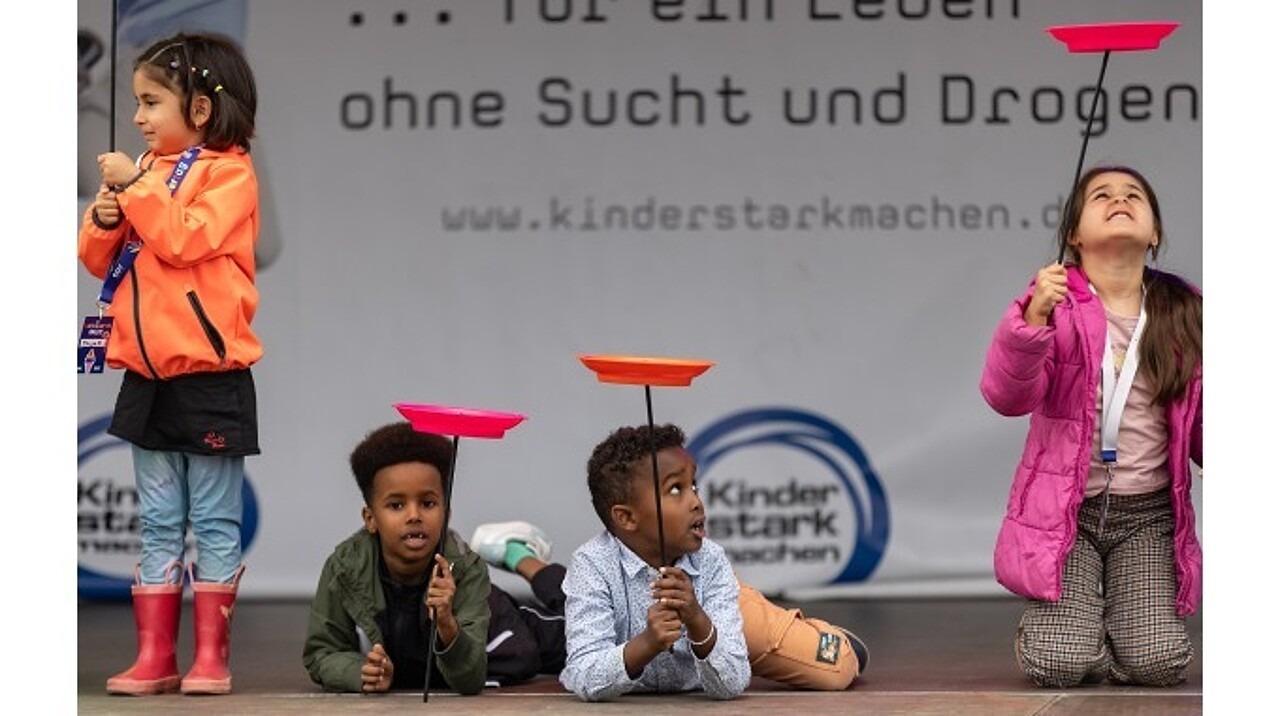 Vier Kinder bei der Tellerakrobatik