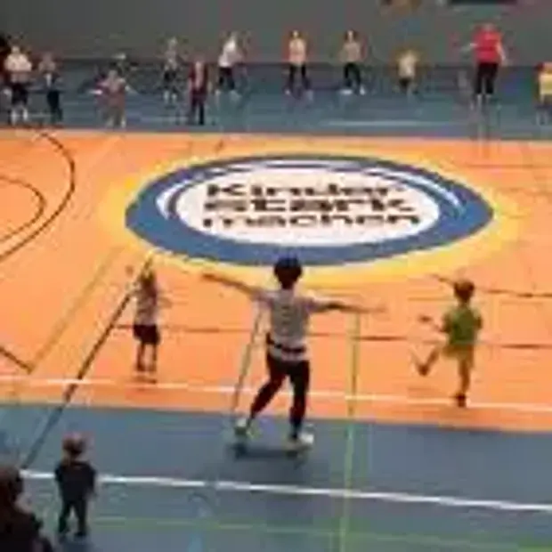 Viele Kinder gemeinsam spannen das Rundbanner mit der Aufschrift „Kinder stark machen“.