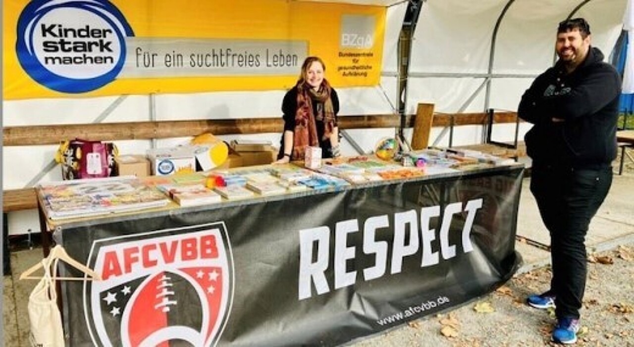 Ansicht eines Informationsstandes mit zwei Personen und einem großen Kinder stark machen Banner