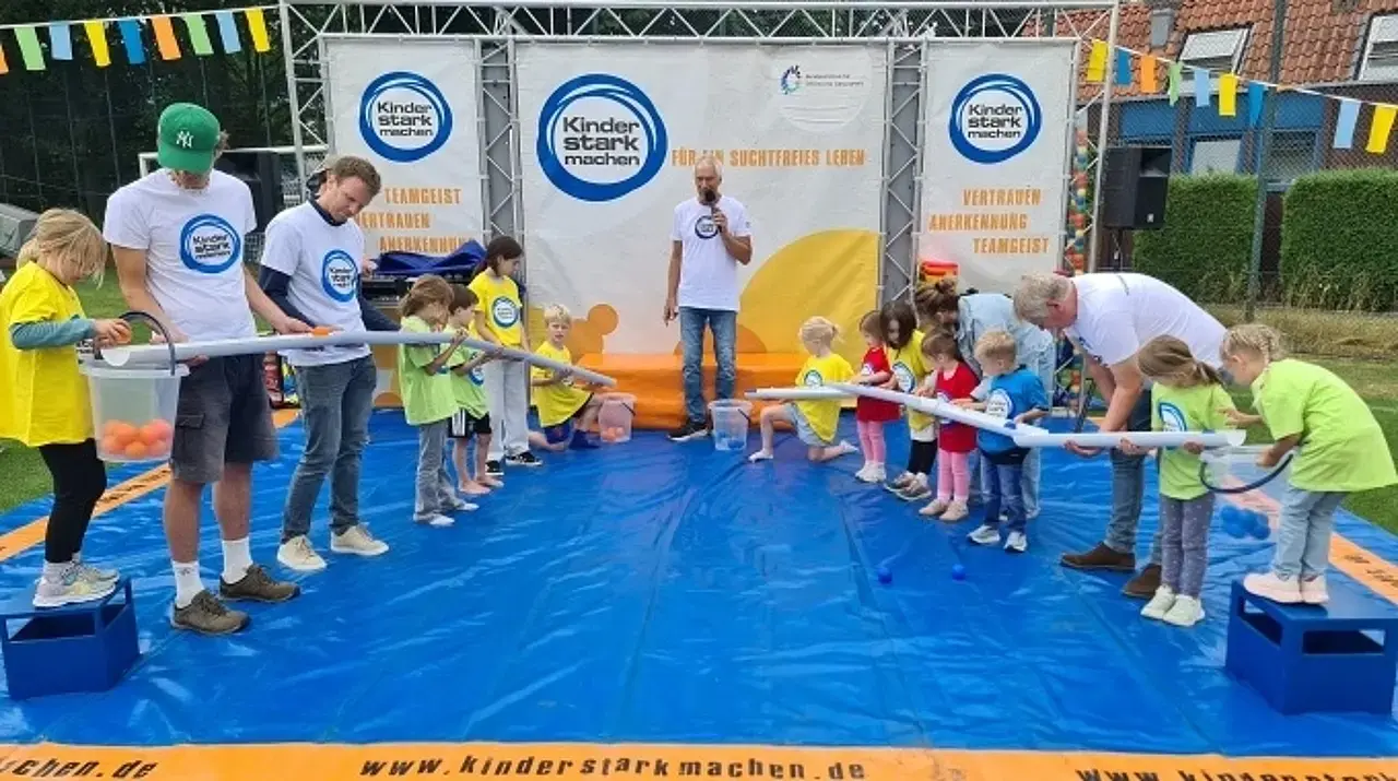 Kinder auf der „Kinder stark machen“-Spielbühne lassen Bälle durch Röhren rollen.