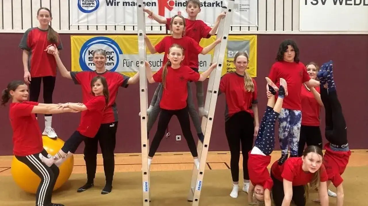 Kinder bilden gemeinsam eine Leiterpyramide.