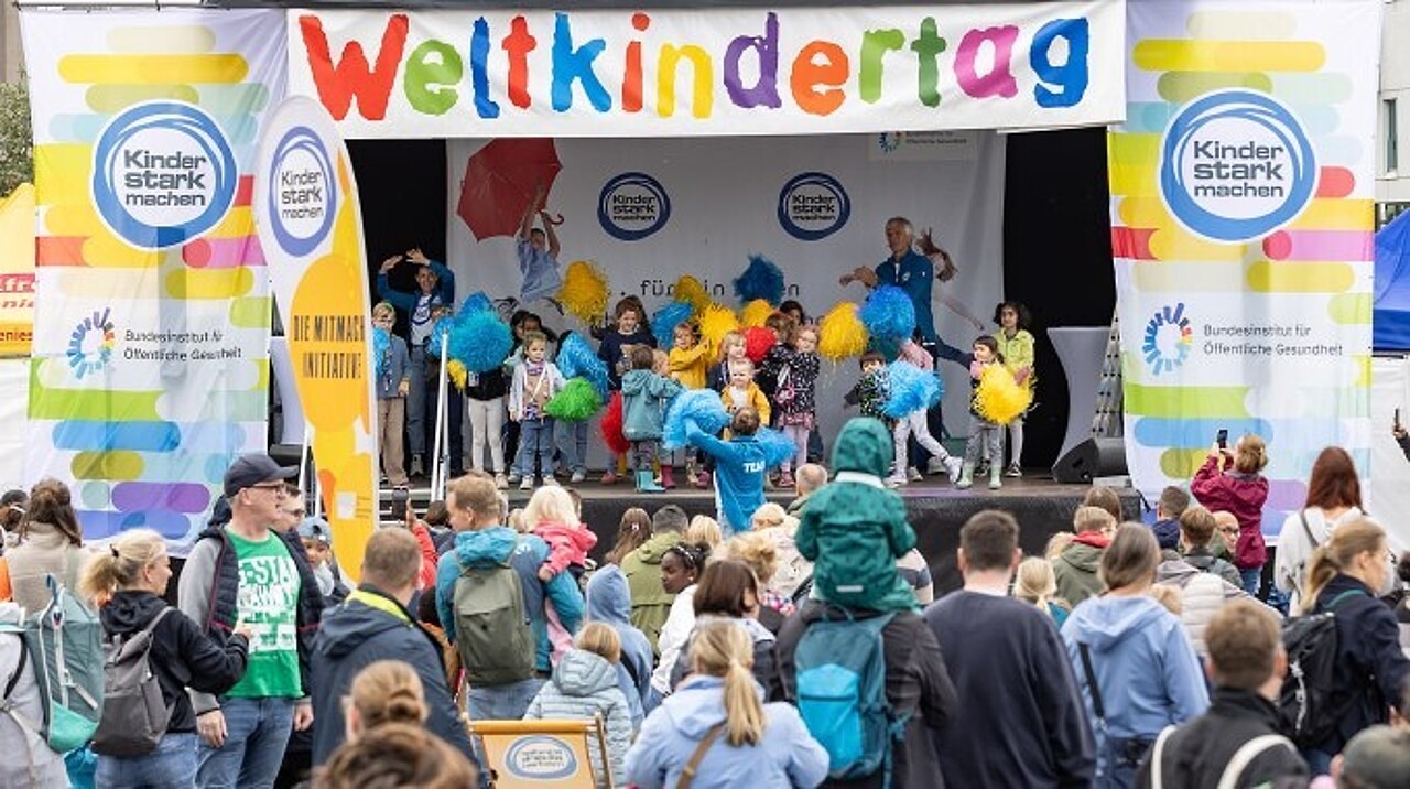 Singa und Kinder wedeln mit Cheerleading-Pompons.