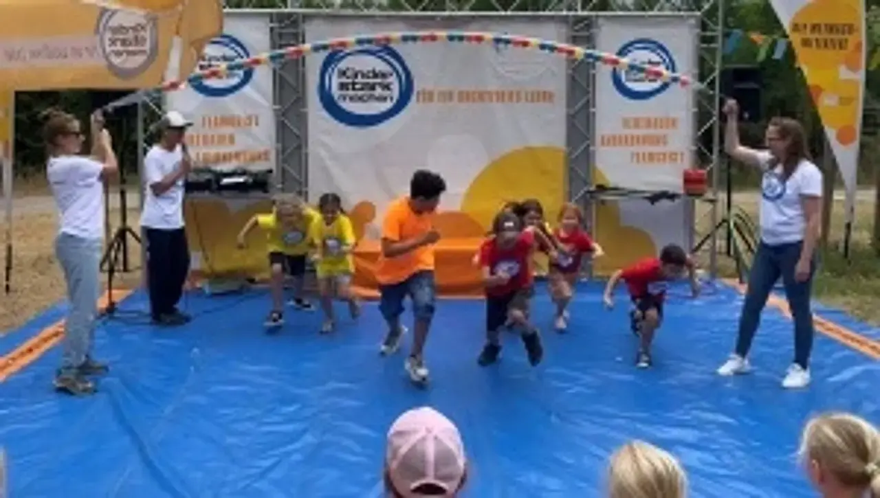  Kinder auf der „Kinder stark machen“-Spielbühne üben sich im gemeinsamen Seilspringen.