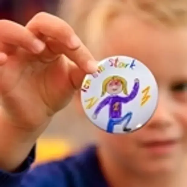 Kind mit einem selbst gestalteten "Ich bin stark"-Button